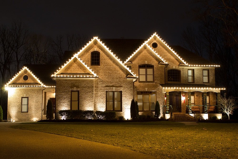 Brick home with white roofline lights at night